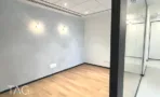 חדר בACRO BUSINESS CAMPUS עם קיר טיח מרוח, תאורת קיר ופרקט עץ - תג נכסים
