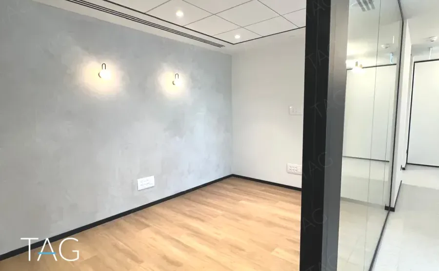 חדר בACRO BUSINESS CAMPUS עם קיר טיח מרוח, תאורת קיר ופרקט עץ - תג נכסים