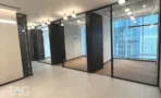 חלל משרדי בACRO BUSINESS CAMPUS עם חדרי זכוכית, תאורה תלויה ונוף עירוני - תג נכסים