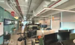 חלל עבודה פתוח עם עמדות מחשב ותקרה טכנית חשופה