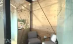 פינת ישיבה מרופדת בחיפוי עץ עם כורסאות וצמחייה