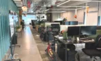 חלל עבודה פתוח עם עמדות, וילון טורקיז ורצפת בטון