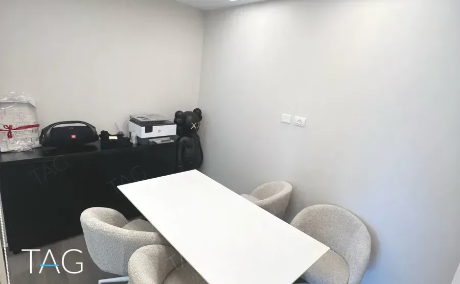 חדר ישיבות עם שולחן לבן וכיסאות מרופדים