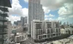 נוף העיר מחלון המשרד, עם מגדל מגורים עגול באופק