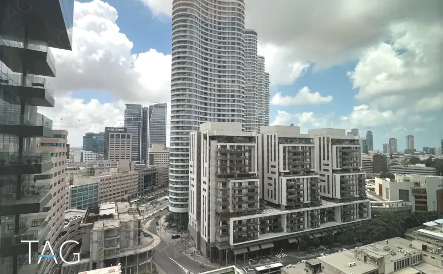 נוף העיר מחלון המשרד, עם מגדל מגורים עגול באופק