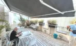 מרפסת גג משותפת עם דק עץ, גגון ואדניות במגדל יובנק UBANK תל אביב