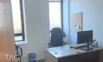 חדר עבודה עם חלון פינתי, שולחן ומסך, ונוף עירוני במגדל יובנק UBANK