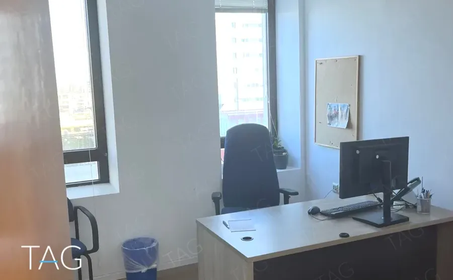 חדר עבודה עם חלון פינתי, שולחן ומסך, ונוף עירוני במגדל יובנק UBANK