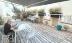 מרפסת גג מרוהטת עם גגון בד, אדניות וישיבה חיצונית במגדל יובנק UBANK