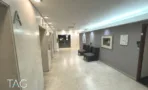 מסדרון קומה מרוצף אבן עם אות קומה על הקיר ופינות ישיבה במגדל יובנק UBANK