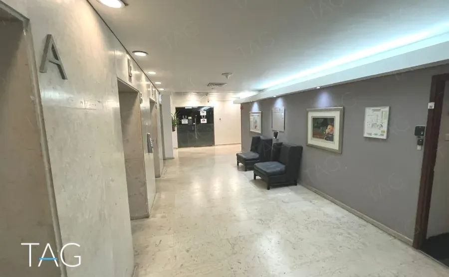 מסדרון קומה מרוצף אבן עם אות קומה על הקיר ופינות ישיבה במגדל יובנק UBANK