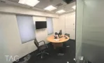 חדר עבודה עם מחיצת זכוכית, מסך על הקיר ושולחן עגול במגדל יובנק UBANK