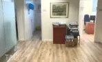 מסדרון פנימי עם ריצוף עץ בהיר, תמונות על הקיר וארכיון קלסרים במגדל יובנק UBANK