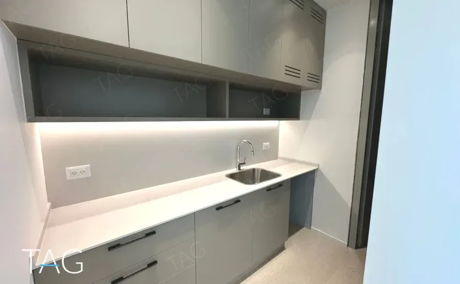 מטבחון אפור עם משטח לבן במשרד במגדל אייקון