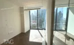 חדר פינתי עם שני קירות חלונות ופרקט כהה במגדל אייקון
