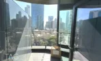 מרפסת מעוגלת עם מעקה זכוכית ונוף עירוני במגדל אייקון