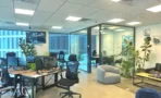 אופן ספייס עם עמדות עבודה וכורסה אפורה במשרד 232 מ״ר במגדל אקרו