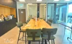 פינת קפה עם דלפק עץ ושולחן ארוך במשרד 232 מ״ר במגדל אקרו