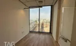 חדר עבודה עם פרקט וחלון הפונה למסילות הרכבת במגדל אייקון