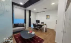 חדר עבודה במשרד בבית אמפא הרצליה עם שולחן, ספה, שולחן עגול ושטיח על פרקט עץ - תג נכסים