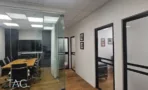 חדר ישיבות מזוגג עם שולחן עץ ומסך קיר, במשרד להשכרה 110 מ