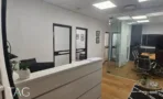 עמדת קבלה לבנה עם מחיצות זכוכית וחדרי עבודה משני צדיה, במשרד להשכרה 110 מ
