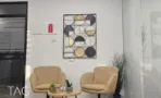 פינת המתנה עם כורסאות בהירות ומיצג קיר גיאומטרי, במשרד להשכרה 110 מ