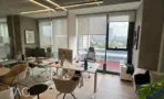 חלל עבודה במשרד במגדלי אלון עם עמדות בהירות, מחיצות זכוכית ונוף