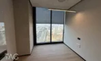 חדר עבודה במגדל אייקון עם חלון גבוה אל נתיבי איילון
