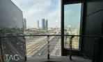 מרפסת מעוגלת במגדל אייקון עם מעקה מתכת מעל נתיבי איילון
