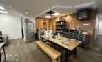 משרד להשכרה 210 מ״ר במגדל פלטינום, מטבחון ופינת אוכל עם שולחן עץ וספסלים
