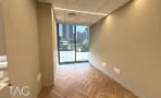 חדר עם פרקט בדגם אדרה וחלון גבוה אל העיר במגדל אייקון