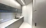 מטבחון עם משטח שיש וארונות אפורים במשרד במגדל אייקון