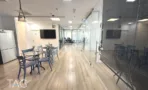 משרד להשכרה 372 מ״ר במגדלי אלון, פינת אוכל עם שולחנות וכיסאות כחולים לצד מחיצות זכוכית