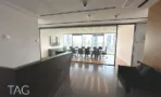 חלל פתוח עם רצפת עץ וחדר ישיבות מזוגג ברקע
