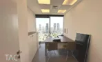 חדר עבודה עם שולחן, ארונות לבנים ונוף העיר