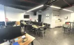 משרד להשכרה 100 מ״ר במגדל WE, חלל עבודה פתוח עם עמדות מחשב ומטבחון