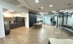 משרד להשכרה 450 מ״ר במגדל פלטינום, מטבח פתוח ושולחן אוכל ארוך לצד חדרים מזוגגים