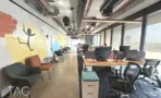 חלל עבודה פתוח עם קיר ציור צבעוני ופינות ישיבה
