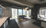 חלל עבודה פתוח עם עמדות, פינת ישיבה ותקרת בטון חשופה