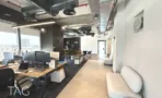 חלל עבודה פתוח עם עמדות מחשב ושטיח כהה