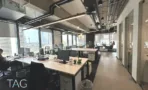 חלל פתוח עם עמדות עבודה, צנרת חשופה ונוף העיר