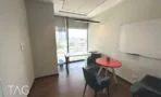 חדר ישיבות עם שולחן עגול אדום ולוח מחיק
