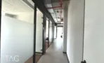 מסדרון עם מחיצות זכוכית וצנרת ספרינקלרים אדומה