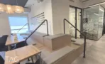 פינת ישיבה מדורגת עם ספסלי ריפוד ומעקה מתכת, במשרד להשכרה 890 מ