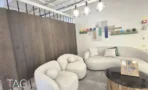 פינת המתנה עם ספה מעוגלת לבנה וקיר עץ, במשרד להשכרה 890 מ