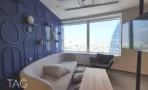 פינת ישיבה עם ספה בהירה מול חלון פנורמי וקיר כחול מעוצב, במשרד להשכרה 890 מ