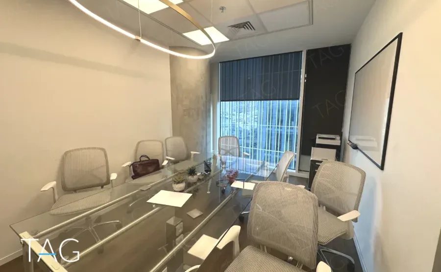 חדר ישיבות עם שולחן זכוכית ותאורת טבעת במשרד 168 מ״ר במגדל אקרו