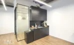 מטבחון המשרד במגדל ספיר עם ארונות כהים ותאורה לינארית