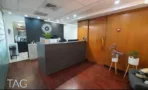 עמדת קבלה עם דלפק כהה וקיר עץ מחופה ברצפת פרקט, במשרד להשכרה בבית מרכז אשדר - תג נכסים